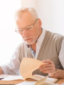 Uma imagem de um idoso lendo informações em papéis.